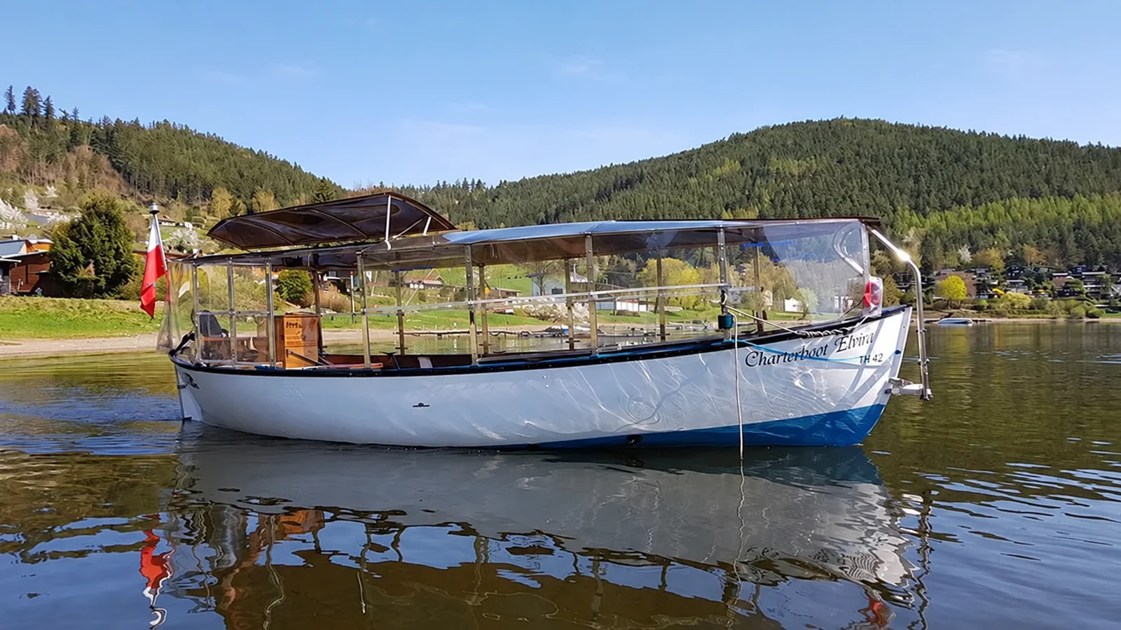 Charter boat Elvira with white hull and covered deck on the Lake Hohenwarte.