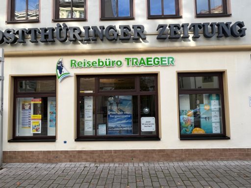 Schaufenster einer Reiseagentur mit Informationen und Plakaten.