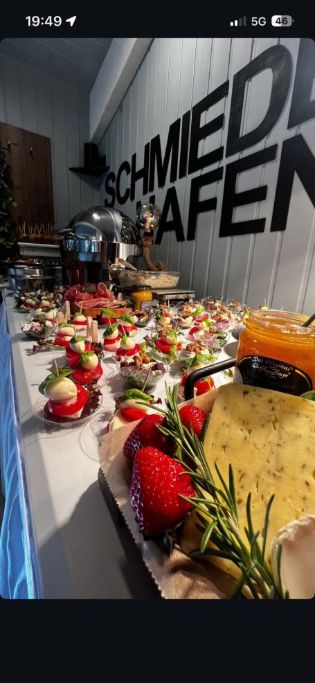Ein Buffet mit frischen Erdbeeren, Käse, und verschiedenen Delikatessen auf einem Tisch.