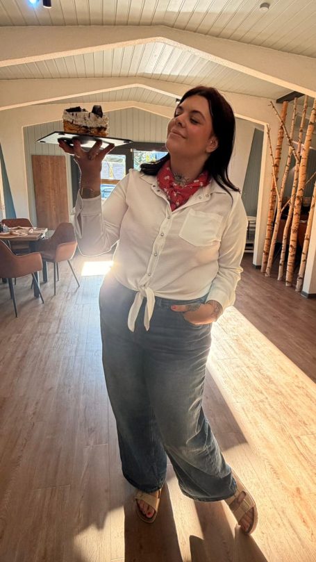 Frau mit Holzschuhen in einer hellen, modernen Innenarchitektur.