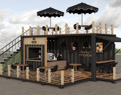 Modular Verkaufsstand mit Holzverkleidung, Tischen, Stühlen und Sonnenschirmen.