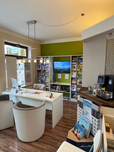 Moderne Büroeinrichtung mit einem Tisch, Stühlen und Regalen, die Broschüren präsentieren.