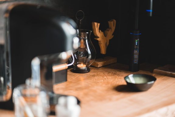 Küchenarbeitsplatte mit Kaffeevollautomat, Glasbehälter und einer kleinen Schale.