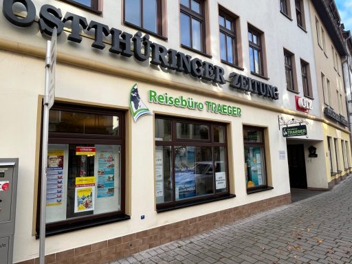 Schaufenster eines Reisebüros mit bunten Plakaten und Werbung.