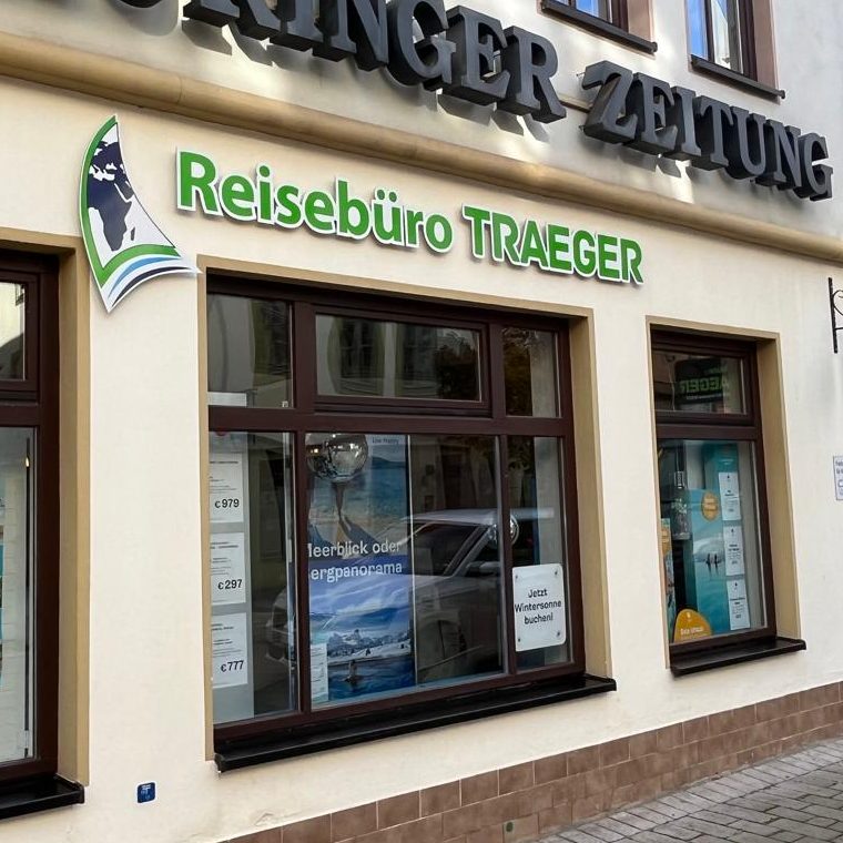 Schaufenster des Reisebüros Traeger mit grüner Beschilderung.