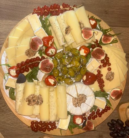 Bunter Käseplatte mit Trauben, Feigen, Nüssen und getrockneten Tomaten.